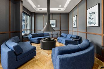 A living room with blue couches and a fireplace.